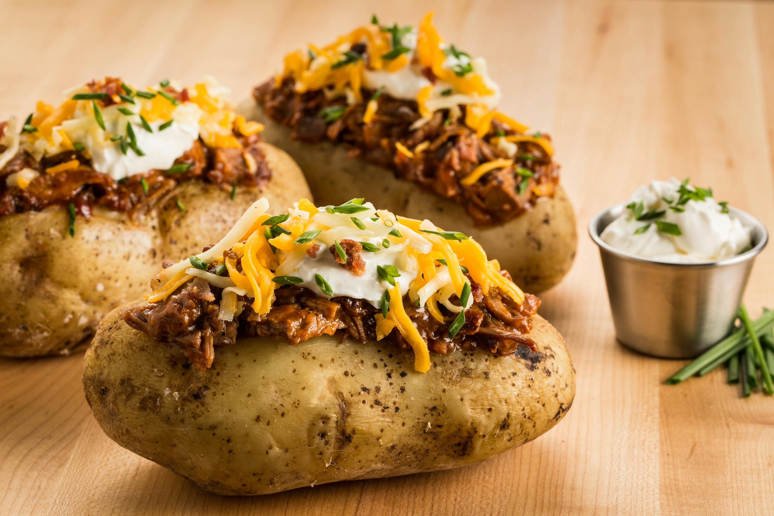 Mouthwatering loaded baked potatoes topped with BBQ beef, cheese, and sour cream.