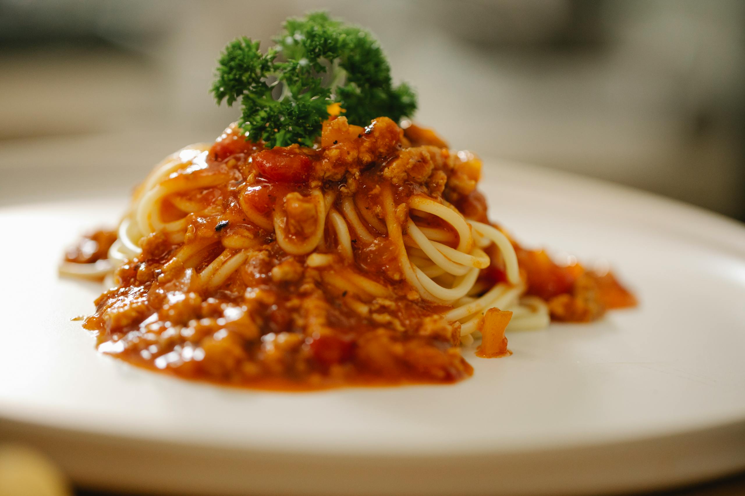 Tasty spaghetti with yummy bolognese sauce served on white plate and garnished with parsley